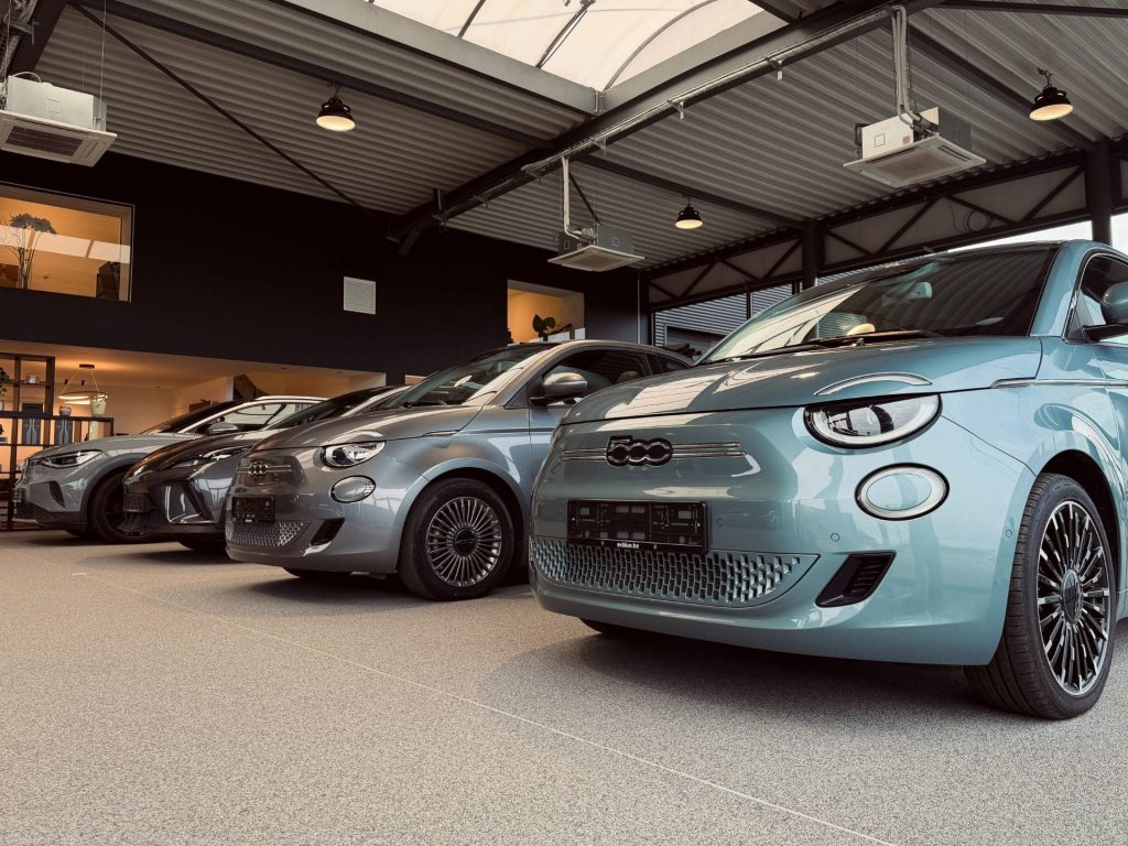 Rangée de Fiat 500e et voitures électriques en exposition dans le showroom EV Blue
